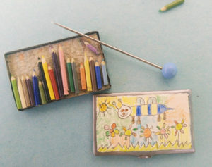 Miniatuur kleurpotloden in doos met tekening op de deksel